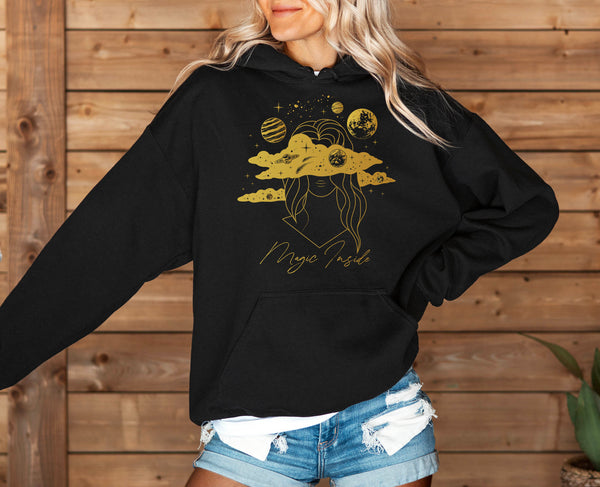 woman wearing a black cosmic celestial hoodie with golden print