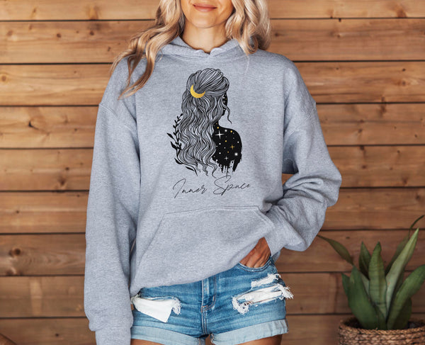 woman wearing a grey spiritual hoodie with girl print from behind and starry sky